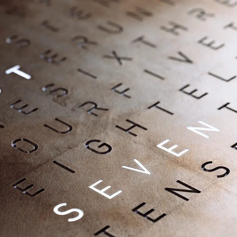 Close-up of QLOCKTWO EARTH 45 Creator's Edition Silver & Gold metal surface crafted with silver and gold leaf