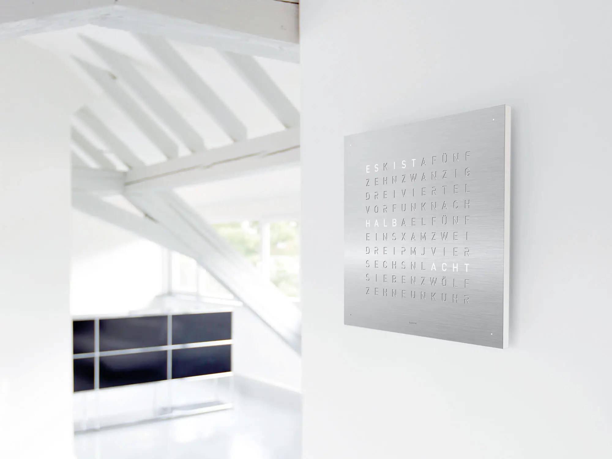 QLOCKTWO EARTH 45 Stainless Steel word clock with brushed metal surface in a modern interior